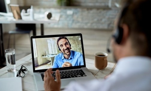 Close-up of businessman talking to his happy colleague over a la